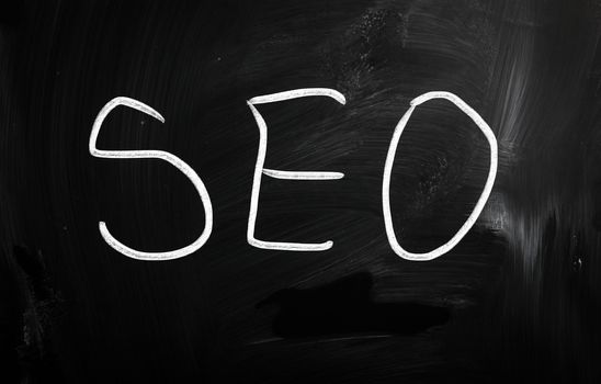 The word "SEO" handwritten with white chalk on a blackboard