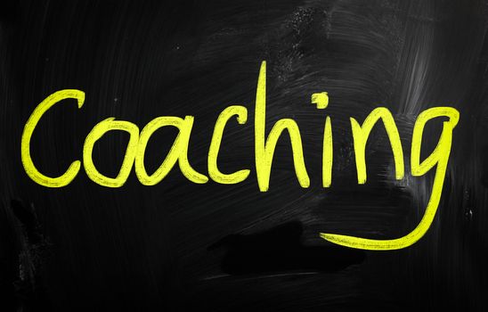 "Coaching" handwritten with white chalk on a blackboard