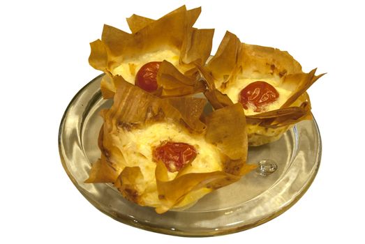 Small homemade pies with cheese and cherry tomato in a basket of pastry