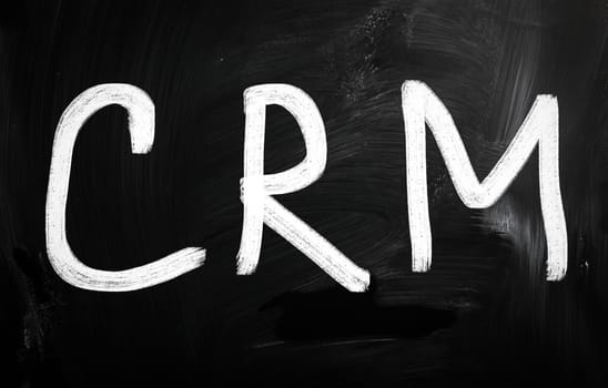 The word "CRM" handwritten with white chalk on a blackboard