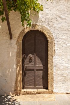 Antique wooden door with metal decor in monastery Touplu, Crete, Greece 