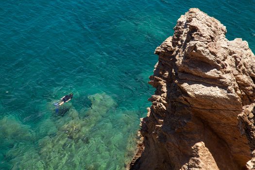 Man snorkeling in clear blue water of Mediterranean Sea, Crete, Greece 