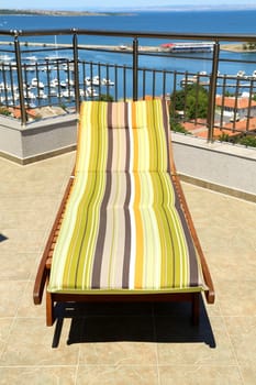 Lonely beach chair against the sea rolling in sky