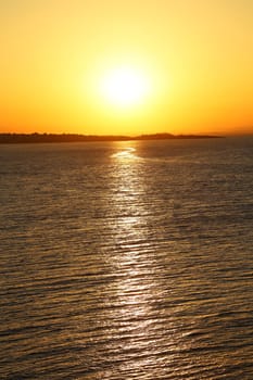 Sunset at the beach. Dark water. Yellow sky.