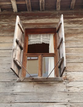 Window of a old wooden house with shutters
