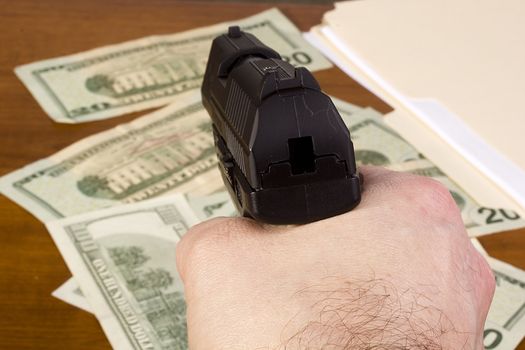 Robbery in the office. Gun in the man's hand on a background of money. The action in the first person.