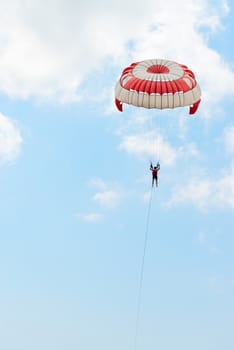 Parasailing under blue sky and white clouds