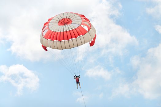 Parasailing under blue sky and white clouds