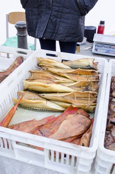 fresh smoked ecologic organic fish in plastic box sold in outdoor market fair. healthy vegetarian food.