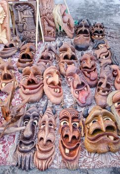 wooden carved funny masks sold in spring fair market. traditional rural crafts.
