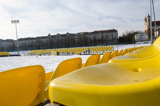 volleyball court yellow plastic chairs row in the winter in center city