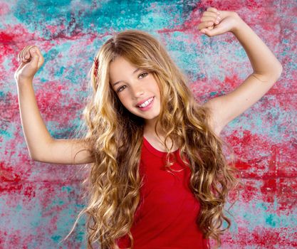 Blond happy children girl in red happy with arms up in grunge background