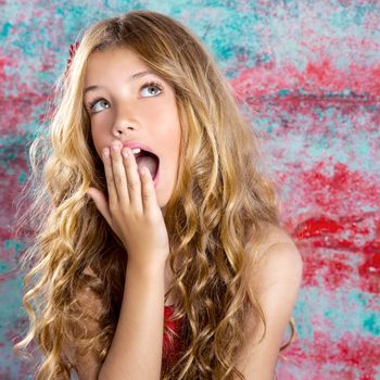 Blond kid girl surprised expression hands in face gesture