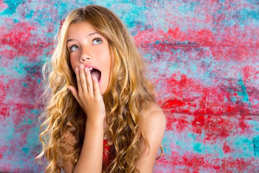 Blond kid girl surprised expression hands in face gesture