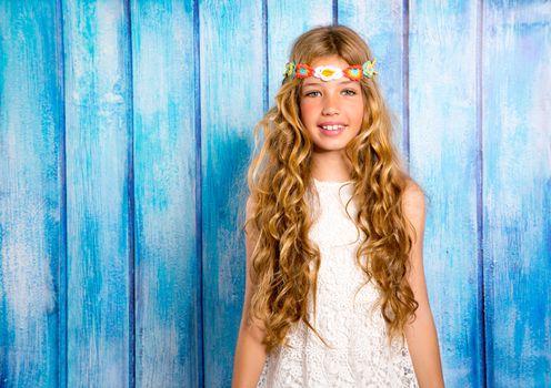 Blond happy hippie children girl smiling on blue grunge wood background