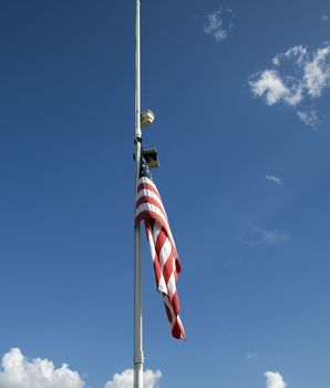American flag at half mast with in the sky background