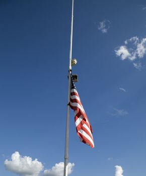 American flag at half mast with in the sky background