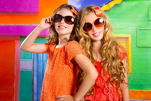 children friends girls with fashion sunglasses in vacation at tropical colorful house