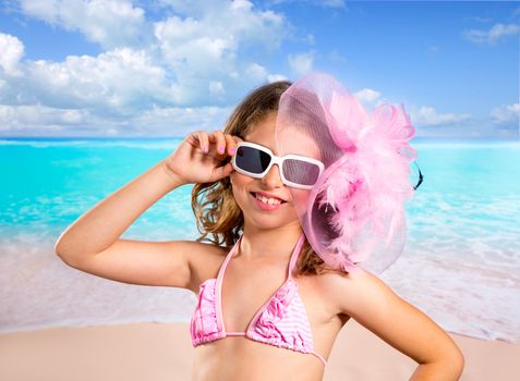 Children girl in tropical turquoise beach vacations with pink fashion style