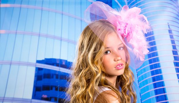 blond fashion girl with pink hat in blue skyscrapers buildings urban background