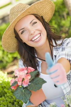 Attractive Happy Young Adult Woman Wearing Hat Gardening Outdoors.