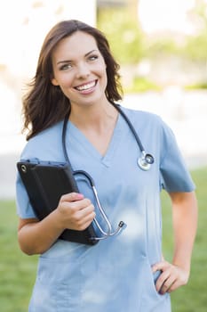 Portrait of An Attractive Young Adult Woman Doctor or Nurse Holding Touch Pad Outside.