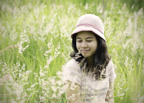 Young brunette woman on the meadow with white flowers on a warm summer day 