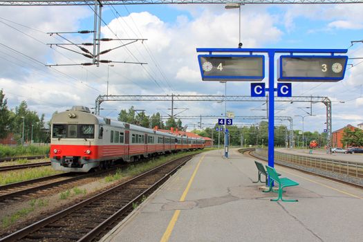 Regional train on an empty platform at a railway station.