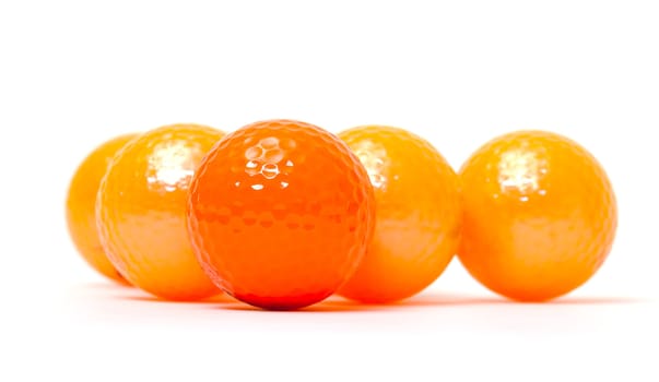 Orange and golden golf balls on white background