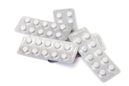 White pills packed in blisters, on white background