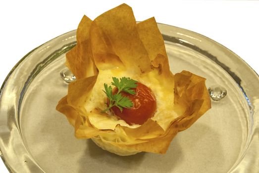 Small homemade pie with cheese and cherry tomato in a basket of pastry