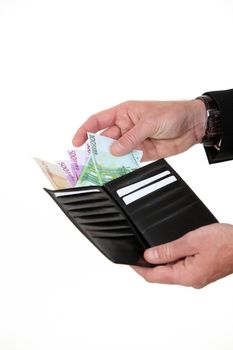 A hand taking bills out of a wallet.