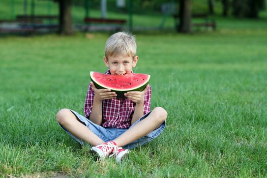 boy eat watermelon in park