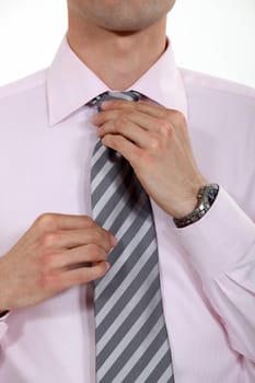 businessman putting his tie on