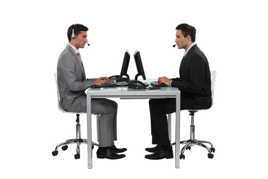 two businessmen working at the same desk