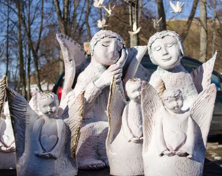 cute white clay ceramic angel sculptures figures looks like alive sold in outdoor market bazaar fair.