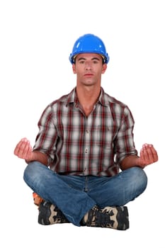 A male construction worker in a yoga position.