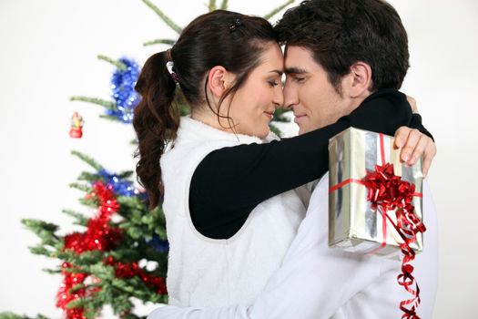 Couple kissing by a Christmas tree