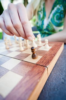 Close up of female hand moves piece in chess