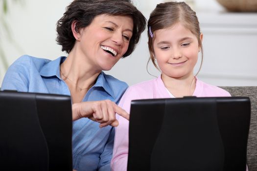 Mother and daughter having fun with their laptops