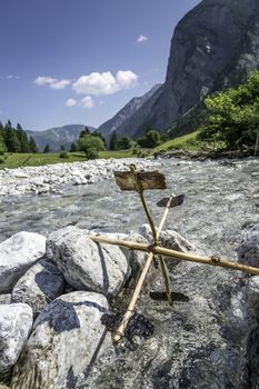 Simple water wheel in a river in the Alps