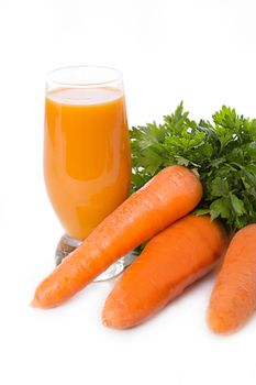 Carrot juice and vegetable with greens over white