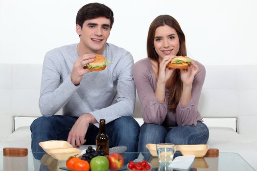 Young couple eating hamburgers