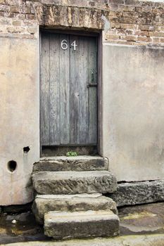 Steps leading up to an old door with the number 64 in the Rocks district of Sydney, Australia