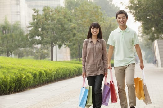 Young couple walking with shopping bags in hands, Beijing, China 