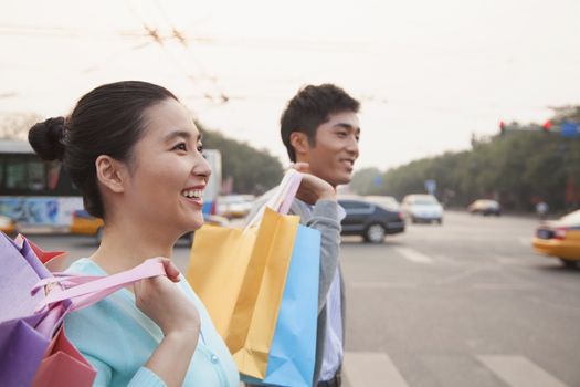 Young couple walking down the street with shopping bags in Beijing