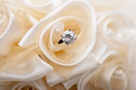 wedding favors and wedding ring on on colored background