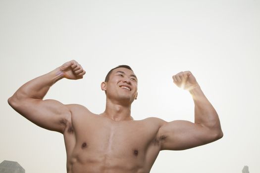 Young Man Flexing Muscles
