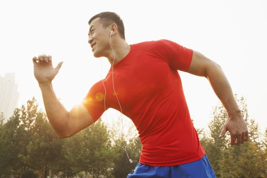 Muscular Man Running and Listening to Music