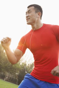 Muscular Man Running and Listening to Music